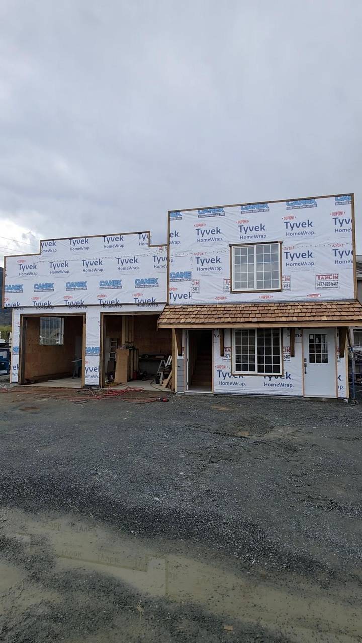 Garage bays open and the shake porch on, before the siding