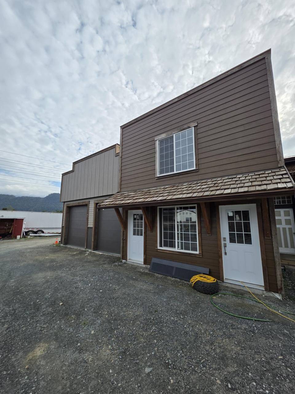 Brown false front with a cedar-shake awning over two white doors
