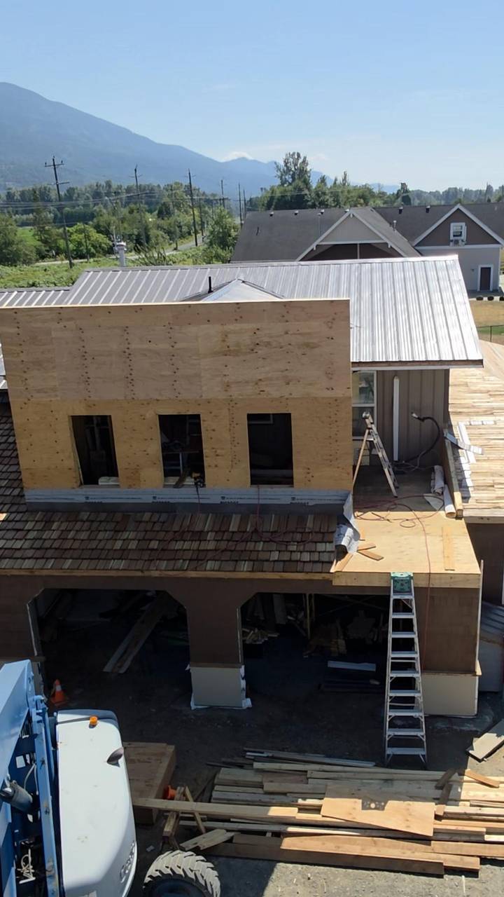 Plywood false front over a cedar-shake porch roof