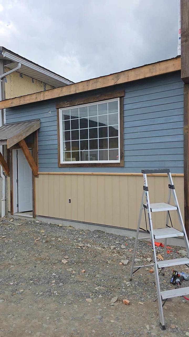 Blue-grey lap siding over beige board on the side of the addition