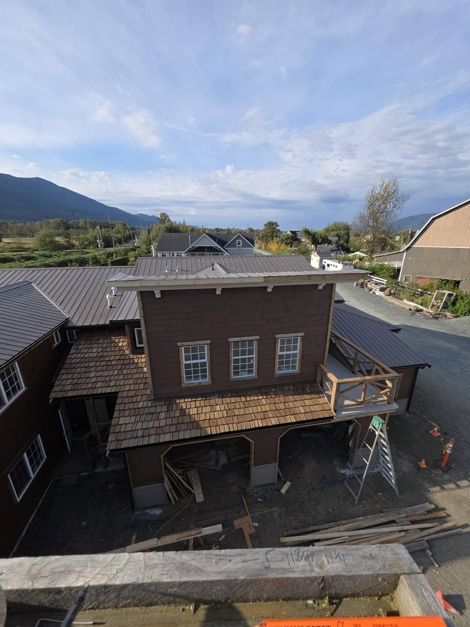 Tower with a shake porch roof, arched bays, and a wood balcony