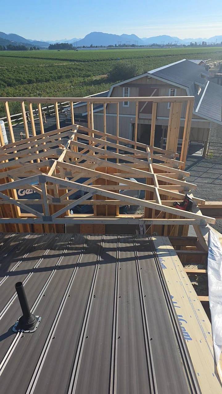 Roof trusses set over the addition, metal panels started below