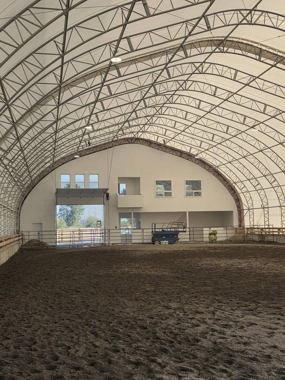 Gable end of a riding arena with a wide door and a viewing loft
