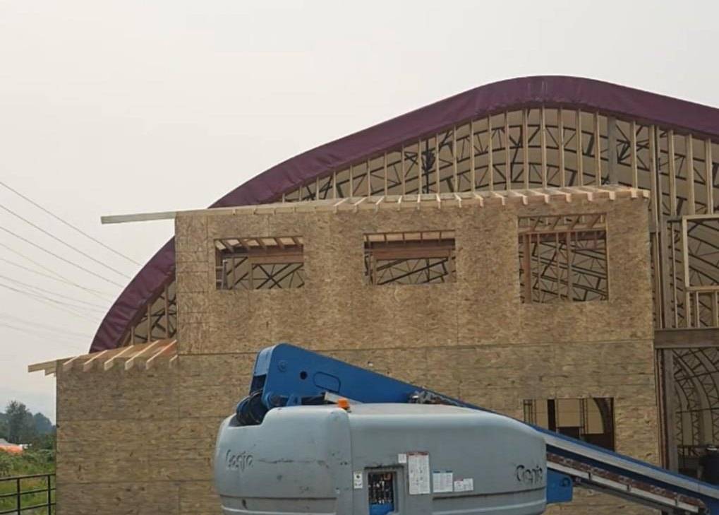 Lift set against the OSB arena wall while the arch is still framed