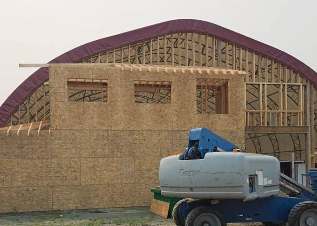 OSB on the arena end wall, lift and stacked lumber in front