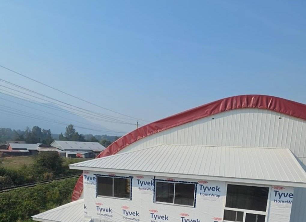 Metal siding on the arena, the upper floor still in house wrap, lift at the wall