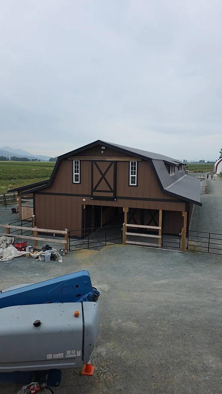 Front of the brown gambrel, crossbuck loft door and the run of stalls