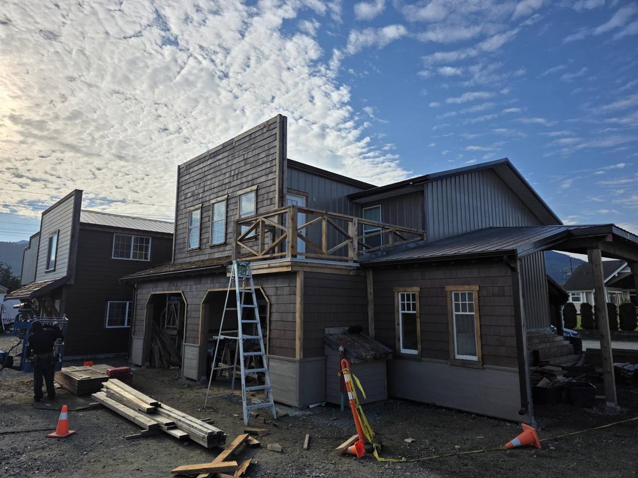 Brown shake siding with a wood balcony and metal roofs