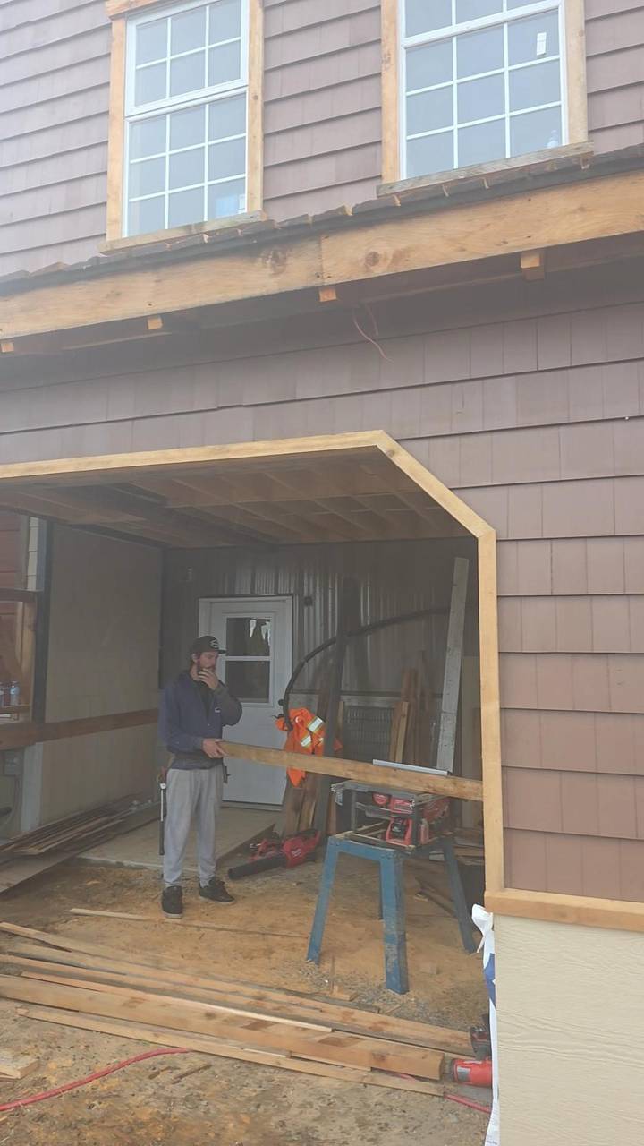 Brown lap siding with a wood-trimmed opening framed into the wall