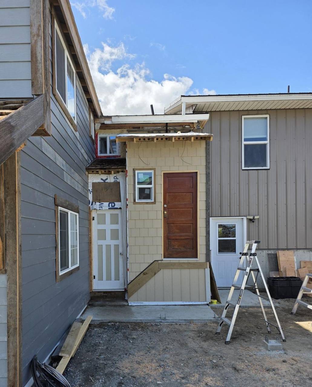 Shake siding going on the entry, wood door set, roof edge still open