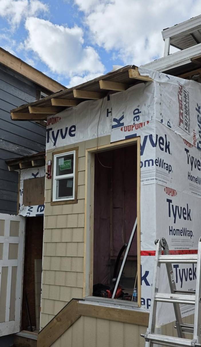 Entry partly sided, the tall face still in house wrap