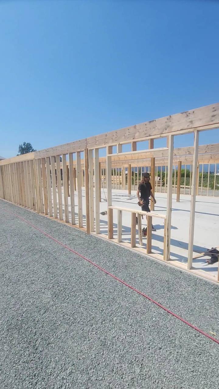 Exterior stud wall on a new slab, with window and door openings framed