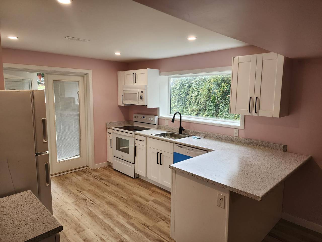 White cabinets, a new range, and a window over the sink