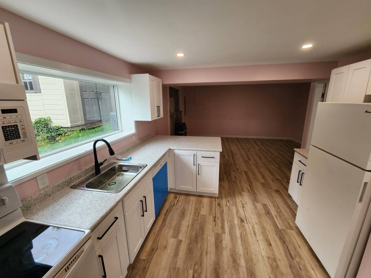 Kitchen opening into the living room, fridge on the right