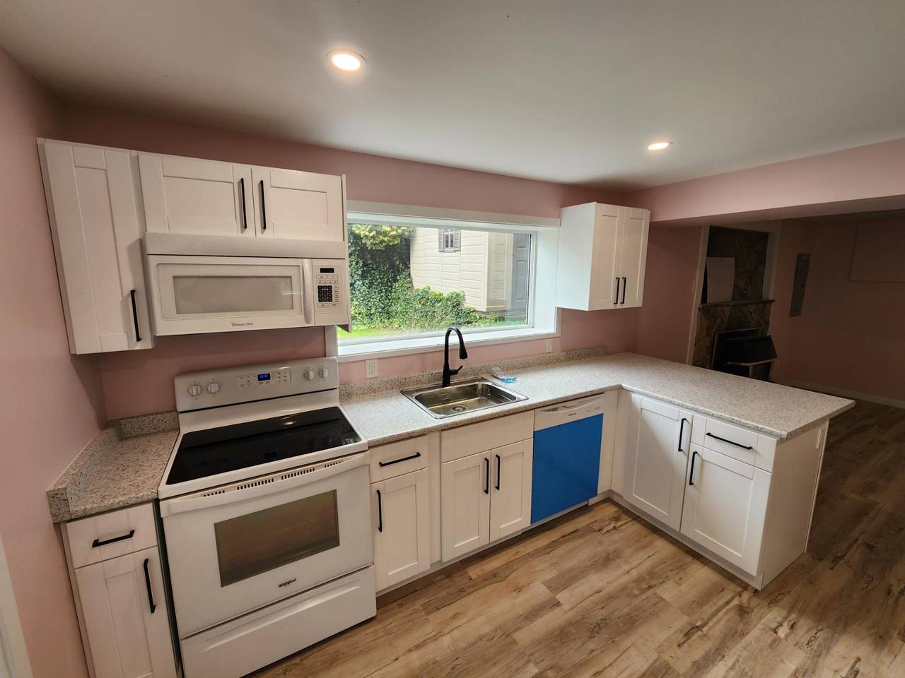Finished kitchen with white shaker cabinets, stone counters, and a new range