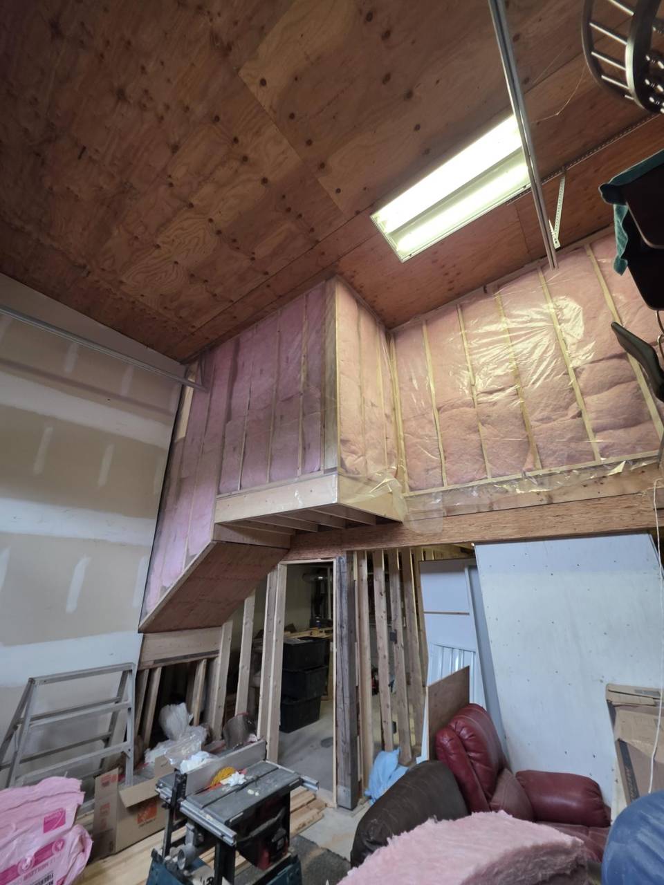 Loft walls filled with batts under a plywood ceiling