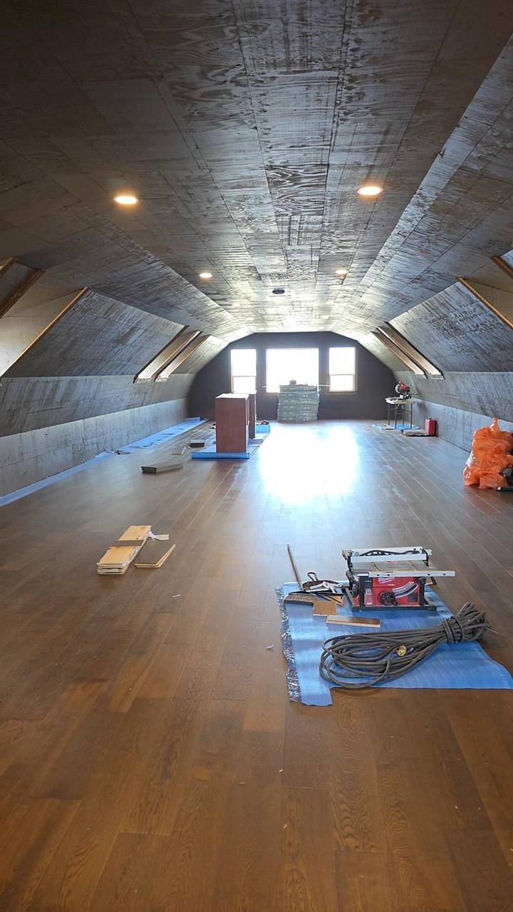 Gambrel loft with the floor down and the ceiling sheathed, windows at the far end
