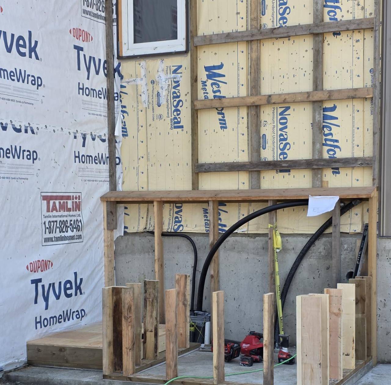 Porch plate and stub posts set on the slab, wall still in house wrap