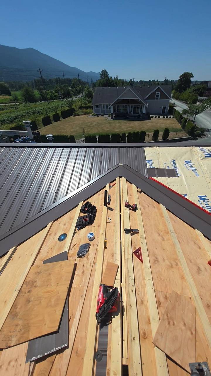 Roof deck going on beside metal panels already laid