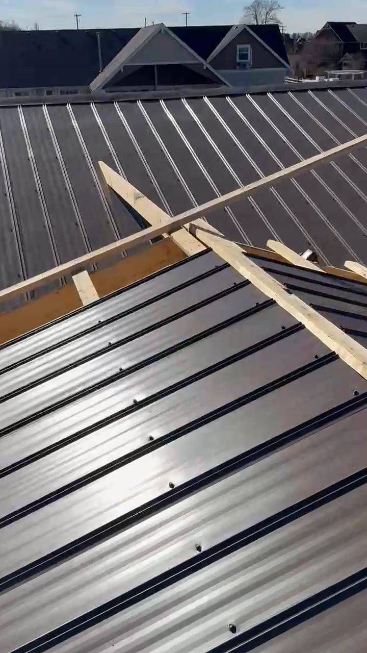 Metal roofing going on over open rafters at a valley