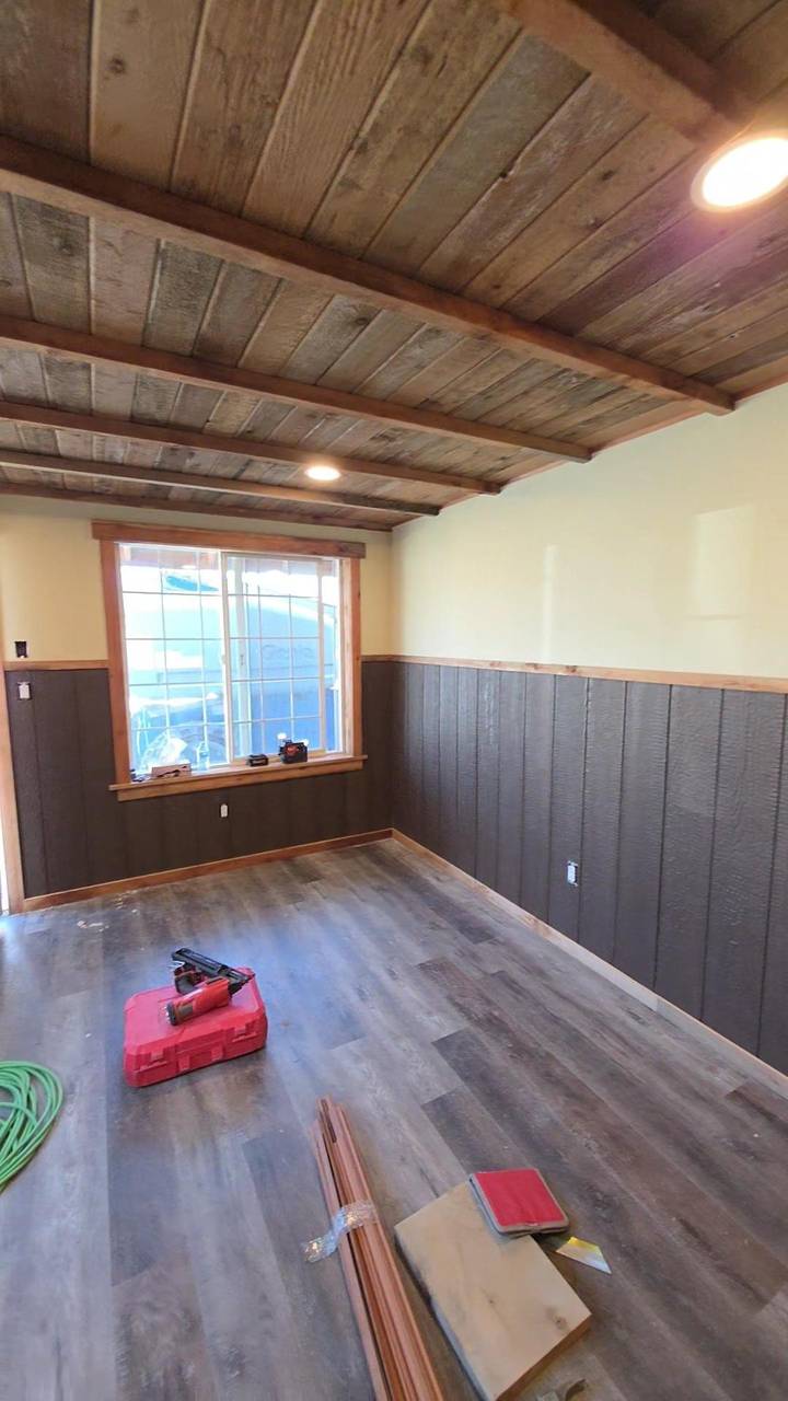 Wood ceiling and two-tone wainscot around a trimmed window