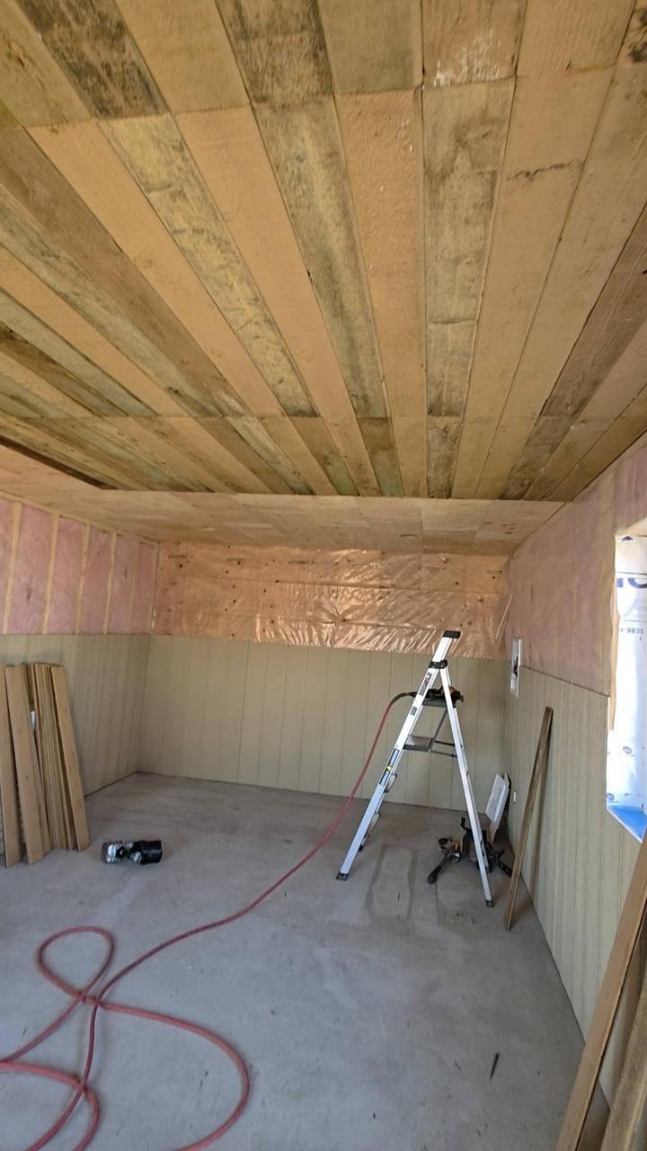 Shop interior with the ceiling decked, walls insulated, and board going on below