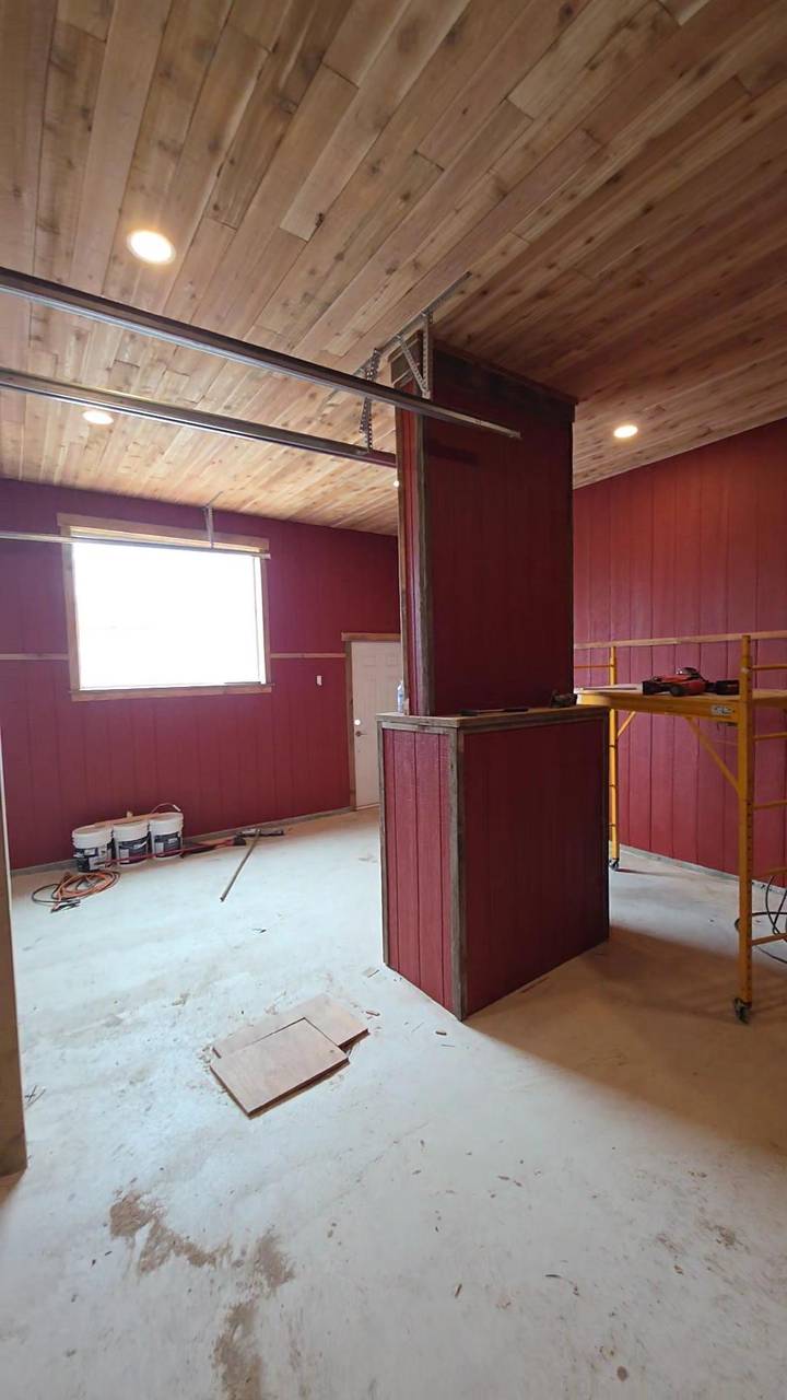 Shop bay with a wood ceiling, red board walls, and a half-wall in the middle