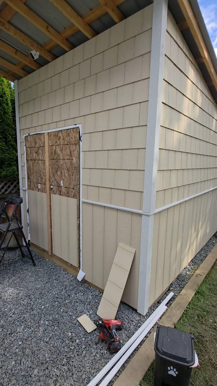 Beige shingle siding at a corner, door opening still sheathed
