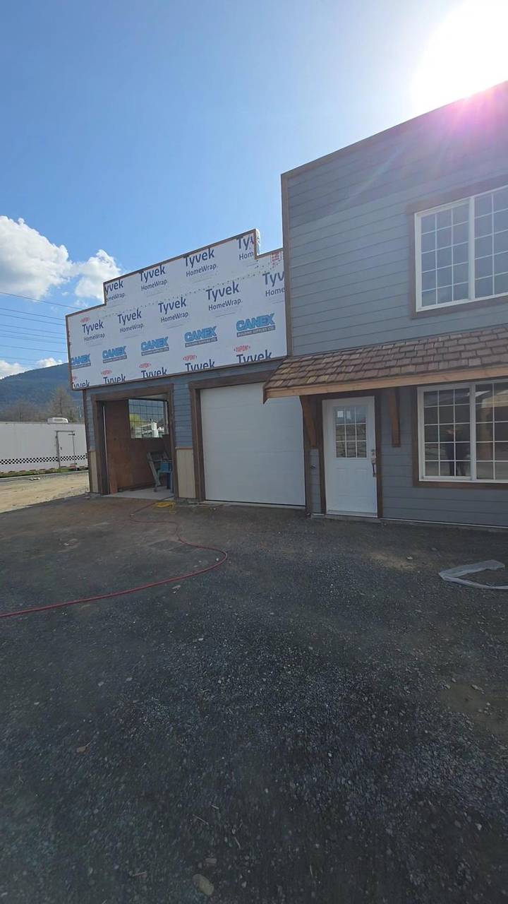 Grey siding started on the right, the garage bays still in house wrap