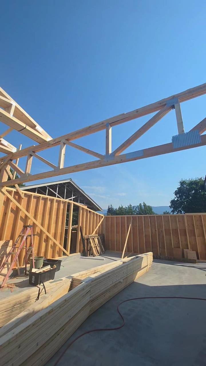 A roof truss with nail plates, framed walls behind it