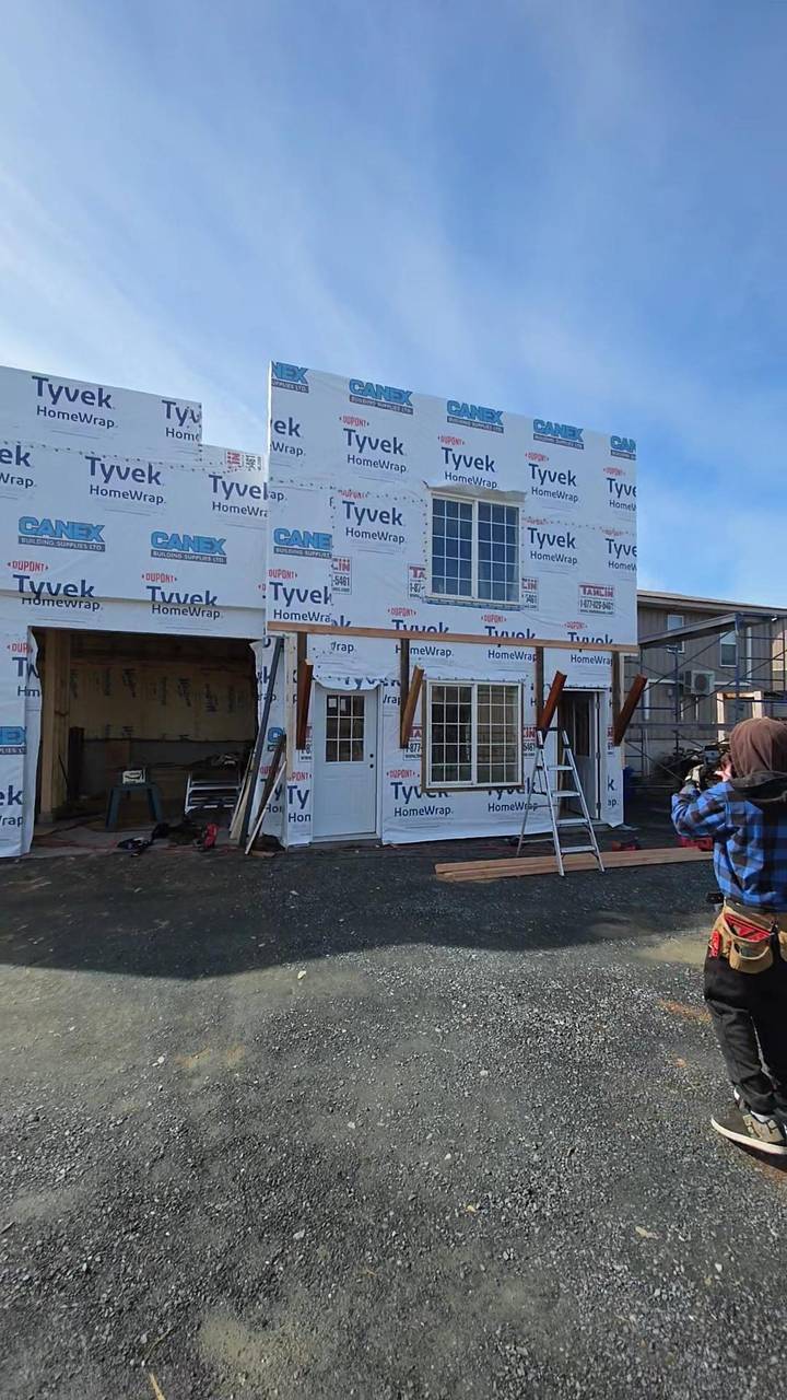 Two-storey house wrapped and ready for siding, windows and doors set